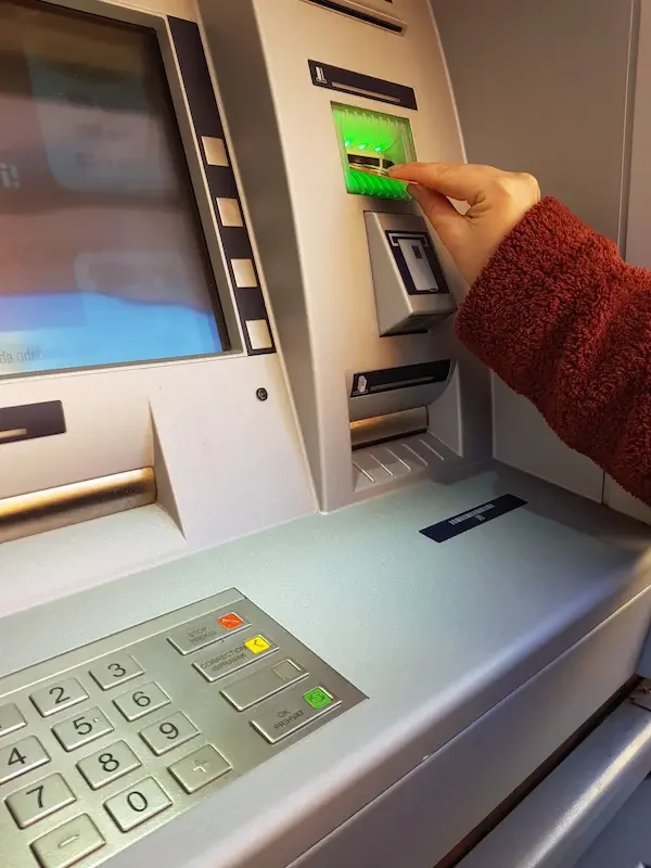 woman-inserting-bank-card-into-atm-withdrawing-money-
